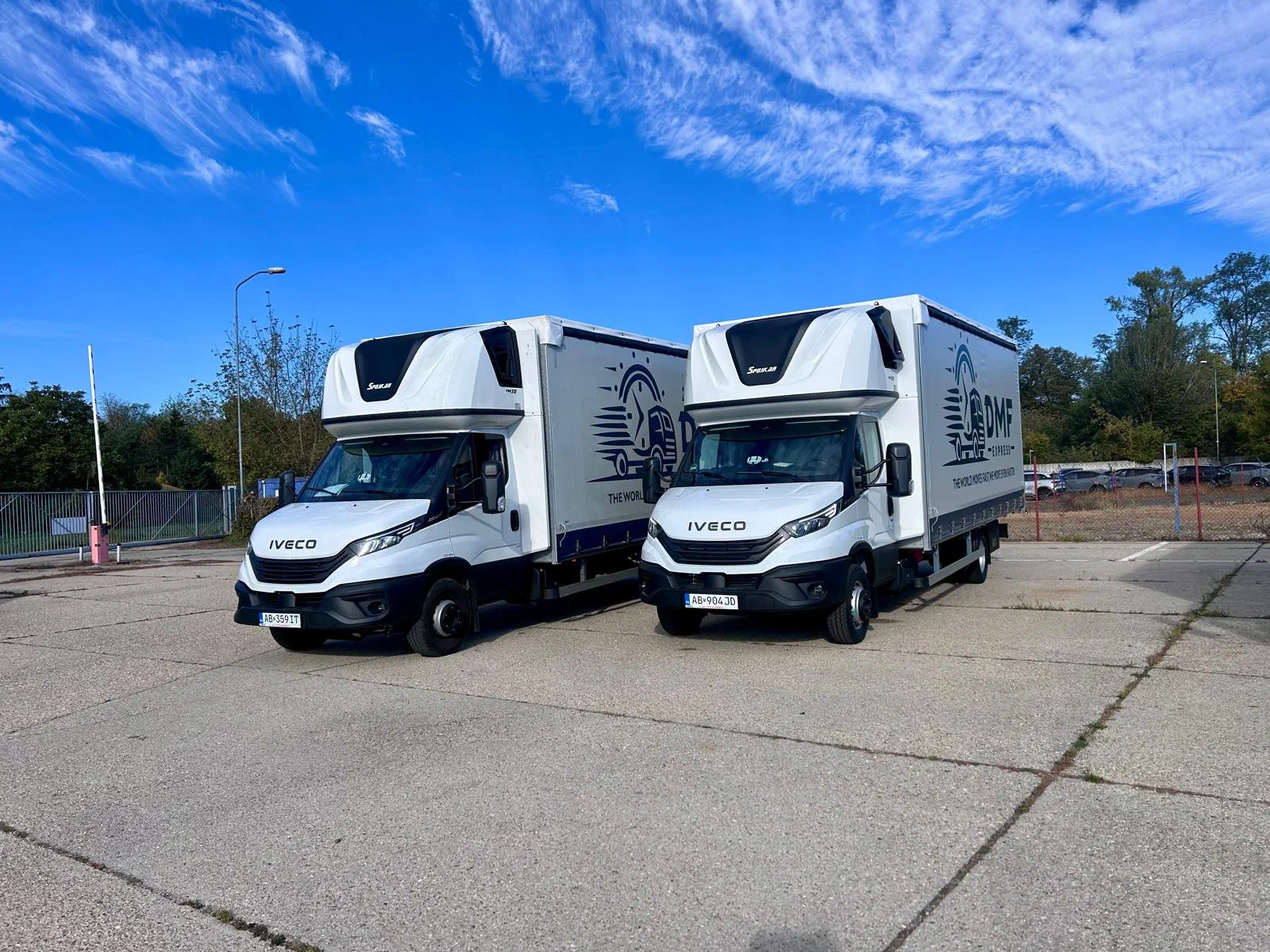 Dve plachtové vozidlá Iveco Daily do 7,2 t s logom DMF Express zaparkované vedľa seba